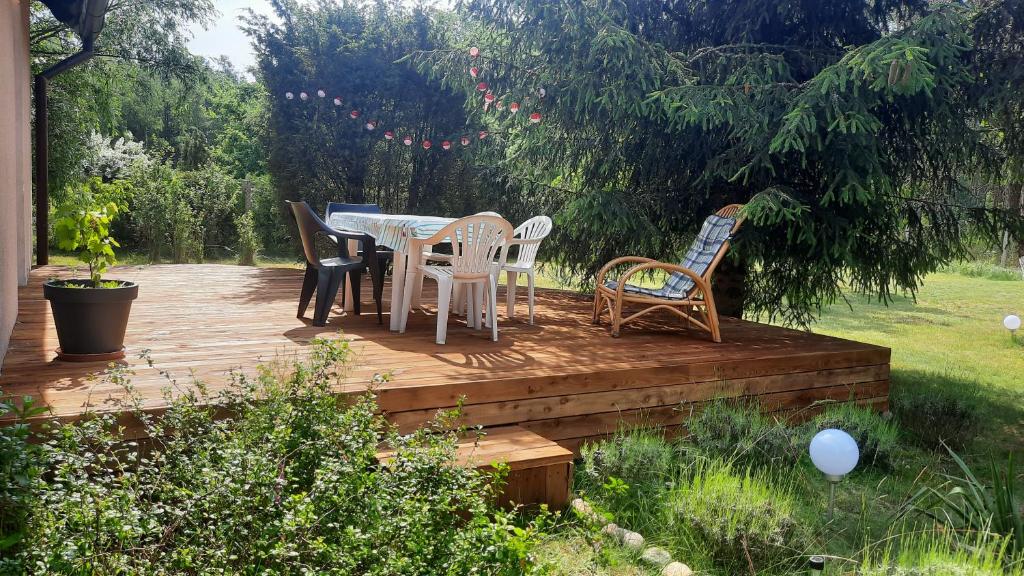 une terrasse en bois avec une table et des chaises. dans l'établissement Borywood, à Małe Gacno