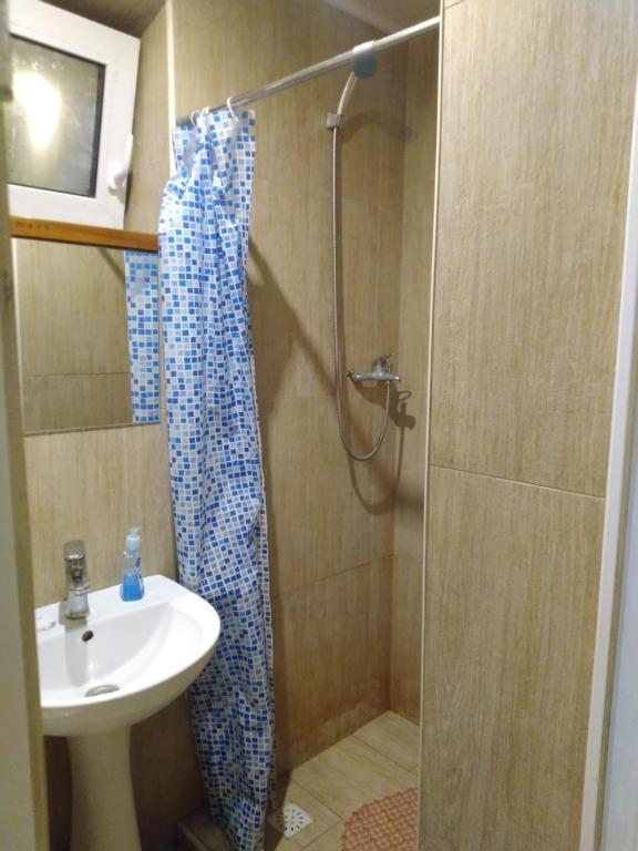 ein Bad mit einer Dusche und einem Waschbecken in der Unterkunft 1 комн квартира, свой двор in Tscherkassy