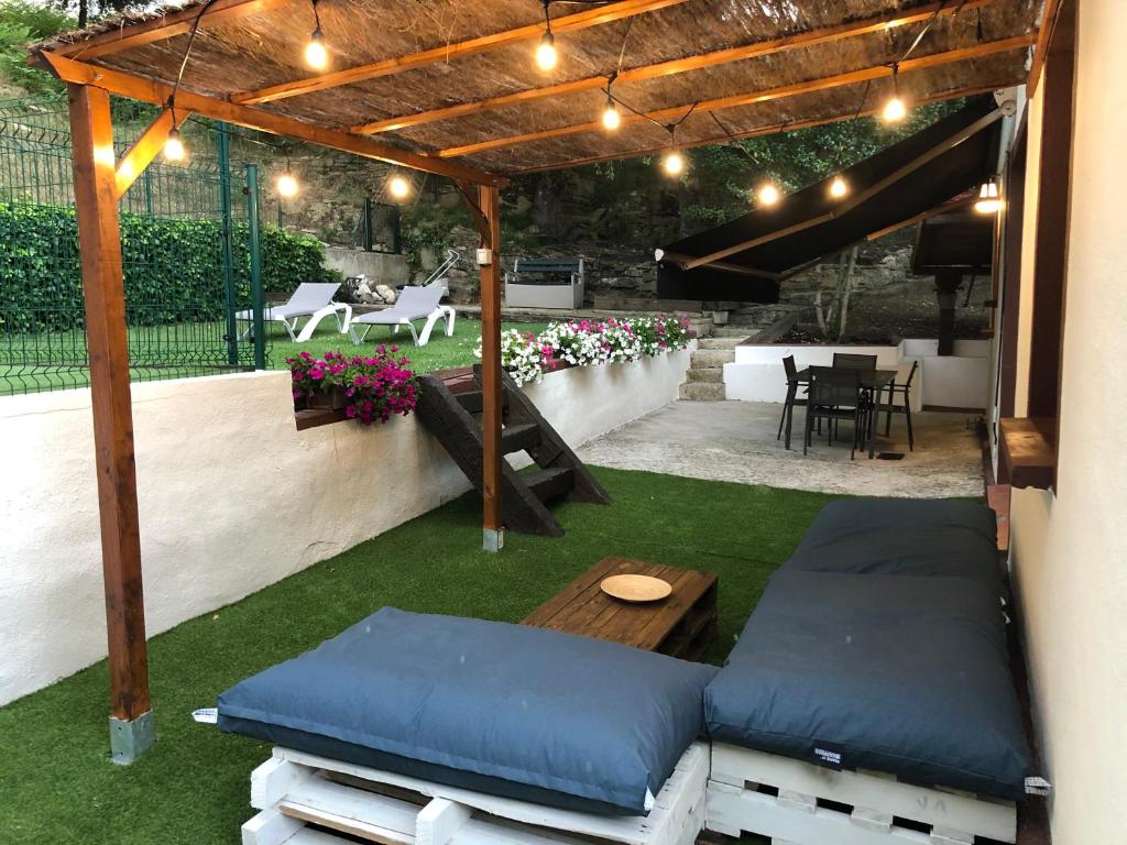 a patio with a pergola with a table and a bench at Casa rural completa en plena naturaleza in Eguíllor