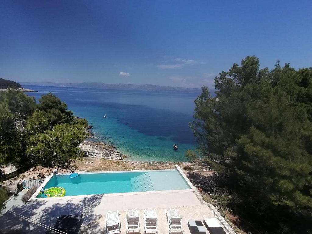 a swimming pool next to a body of water at Holiday house Karla in Vela Luka