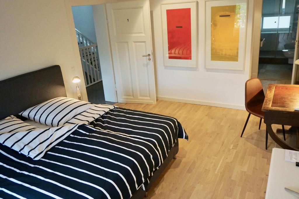 Schlafzimmer mit einem Bett mit blauen und weißen Streifen in der Unterkunft Privatzimmer Schönfelder in Düsseldorf