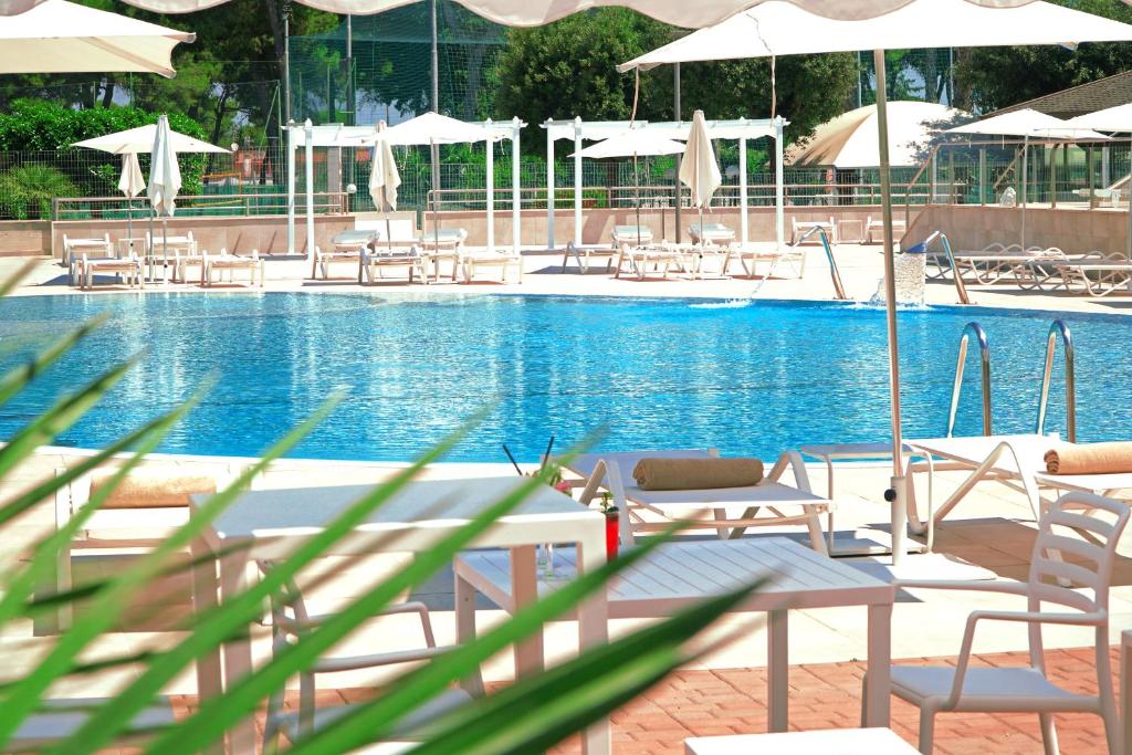 a large swimming pool with chairs and umbrellas at Tursport in Taranto