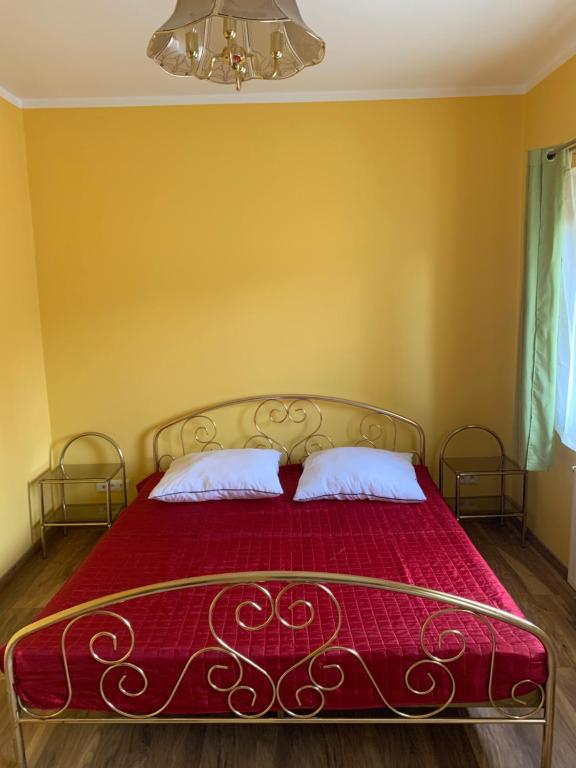a bedroom with a red bed with two pillows at Agroturystyka Sokoliki in Karpniki