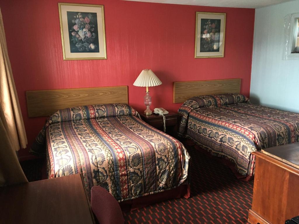 a hotel room with two beds and red walls at Northland Motel Bay City-Kawkawlin in Kawkawlin