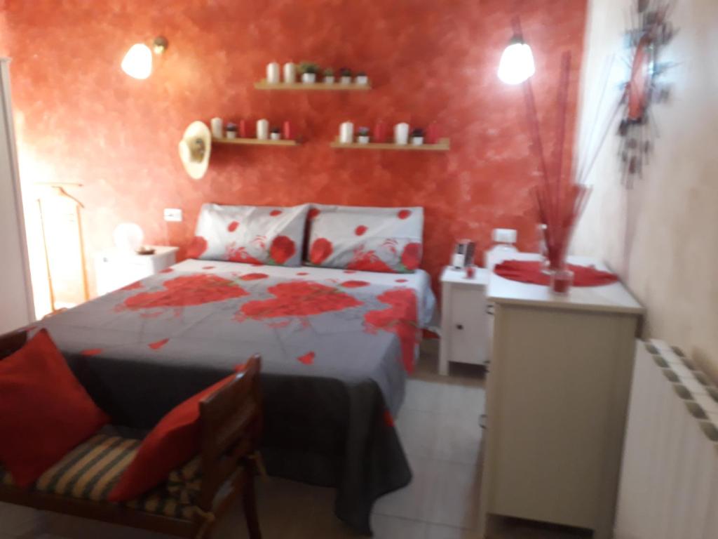 a red bedroom with a bed and a chair at Suites Rome in Pescara