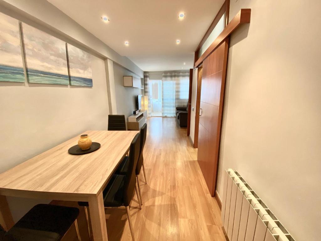 Habitación con mesa de madera y comedor. en Ridaura Center Apartment, en Platja d'Aro