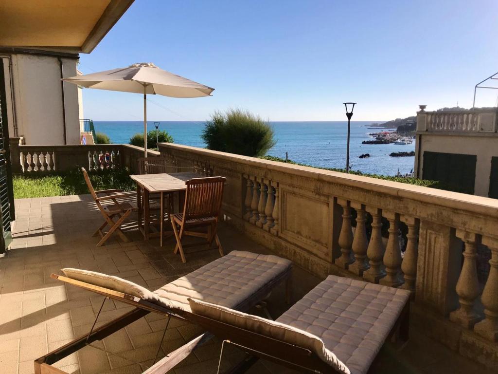 a balcony with a table and chairs and an umbrella at Appartamenti fronte mare in Castiglioncello