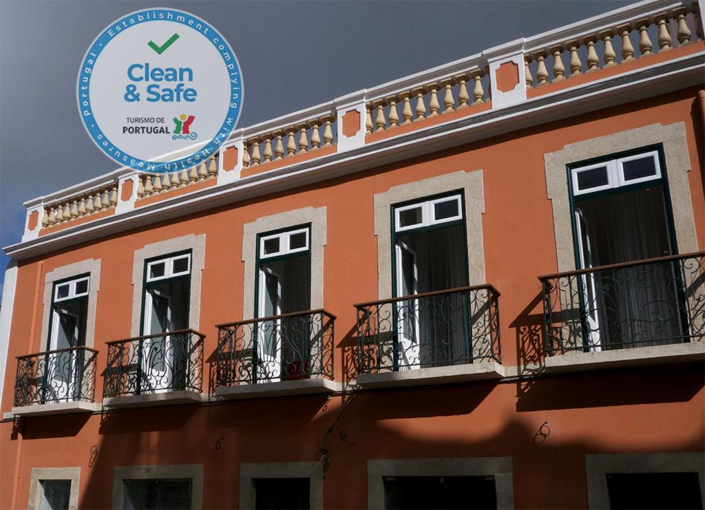 un edificio con balcones y un cartel que diga limpio y seguro en Cacilhas Guest Apartments en Almada