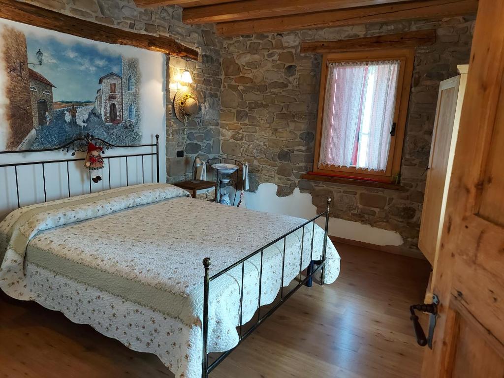- une chambre avec un lit dans une pièce dotée d'un mur en briques dans l'établissement B&B Alla Lanterna, à Trichiana