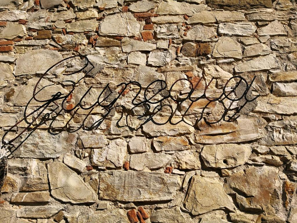 Una pared de piedra con un graffiti. en La Giuncaia en Pieve Santo Stefano