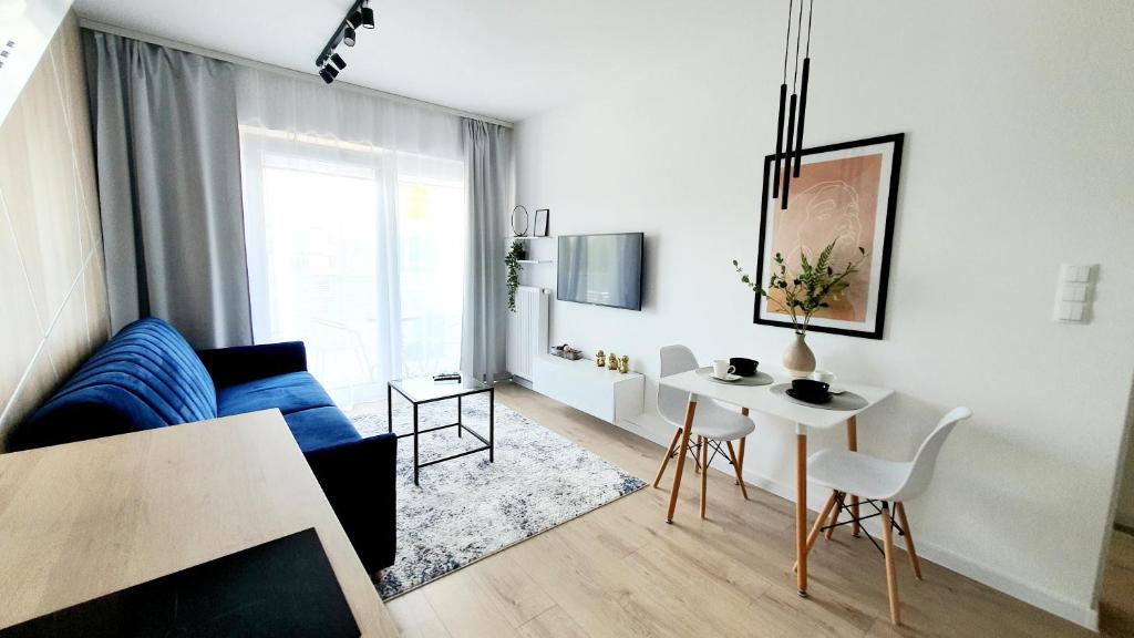 - un salon avec un canapé bleu et une table dans l'établissement Apartament SONIA SAUNA-TARGI-GARAŻ, à Kielce