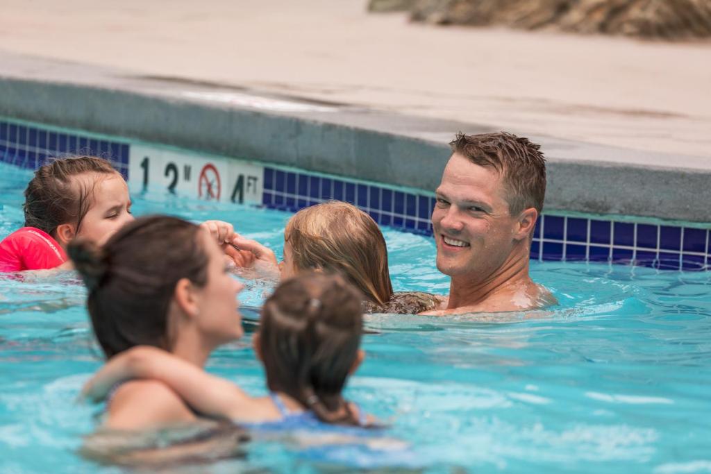 a group of people in a swimming pool at Blackcomb Springs Suites by CLIQUE in Whistler