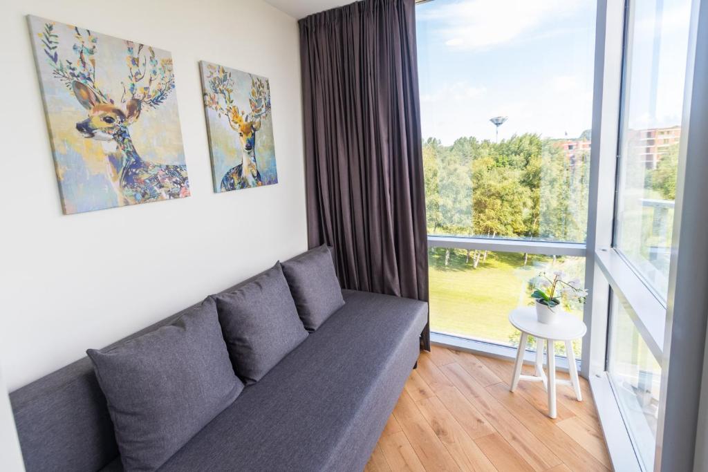 uma sala de estar com um sofá e uma grande janela em Favorite apartment Elija, Sventoji em Šventoji