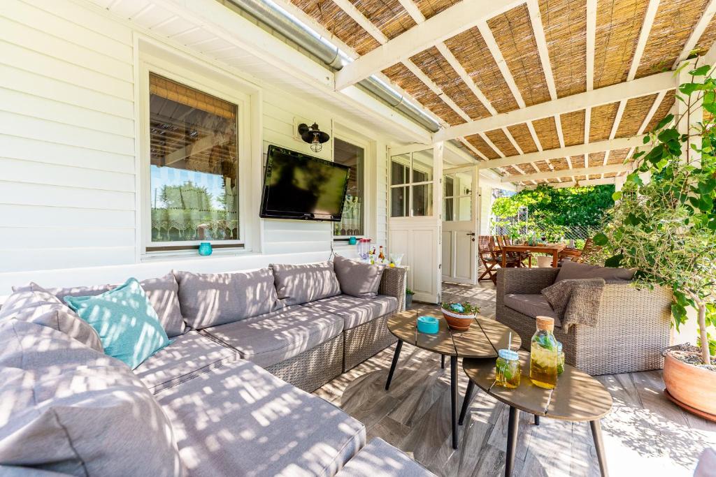 patio con divano e TV di Berrybay Holidayhome a Balatonkeresztúr