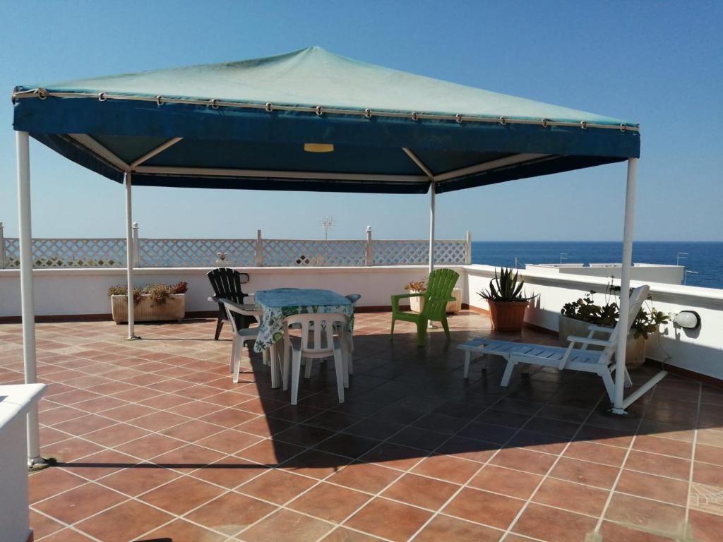 un tavolo e sedie sotto un ombrellone blu su un tetto di Montedarena GOLD a Pulsano