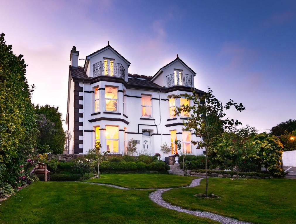 a large white house with a yard at Rockleigh Place in St Austell