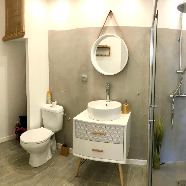 un bagno con un water, un lavandino e uno specchio di Coco Paradise a Le Diamant