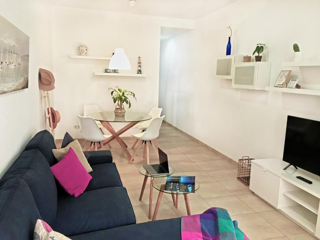 - un salon avec un canapé bleu et une table dans l'établissement Citybeach - parking & wifi, à Las Palmas de Gran Canaria
