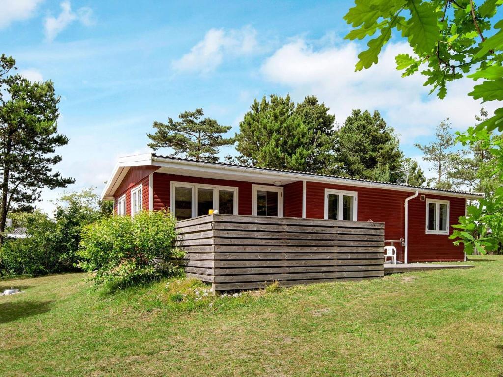 エーベルトフトにあるHoliday home Ebeltoft LIの庭付き丘の上の赤い家