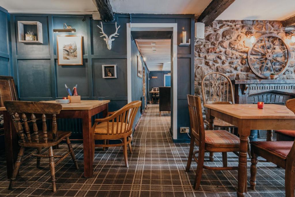 uma sala de jantar com mesas e cadeiras de madeira em Royal Oak Appleby em Appleby