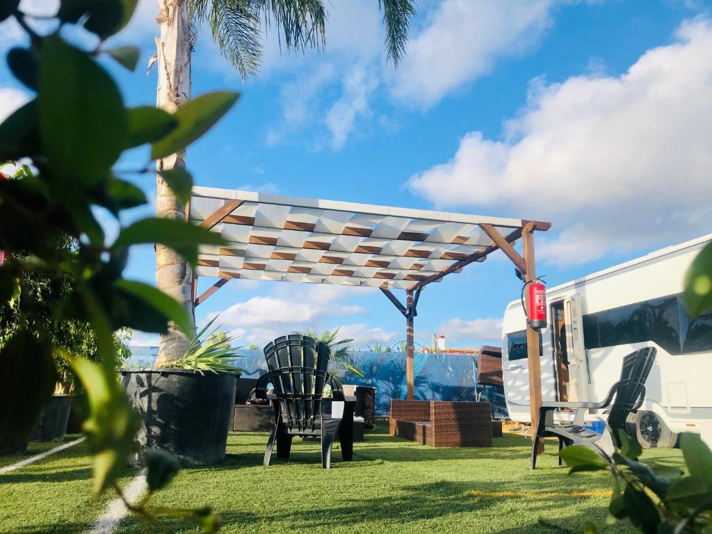 una pérgola en un patio junto a un remolque en Caravanas Con Encanto El Palmar en El Palmar