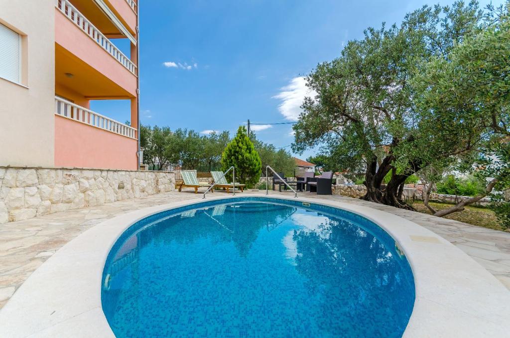 a swimming pool in the backyard of a house at Apartments Melita in Trogir
