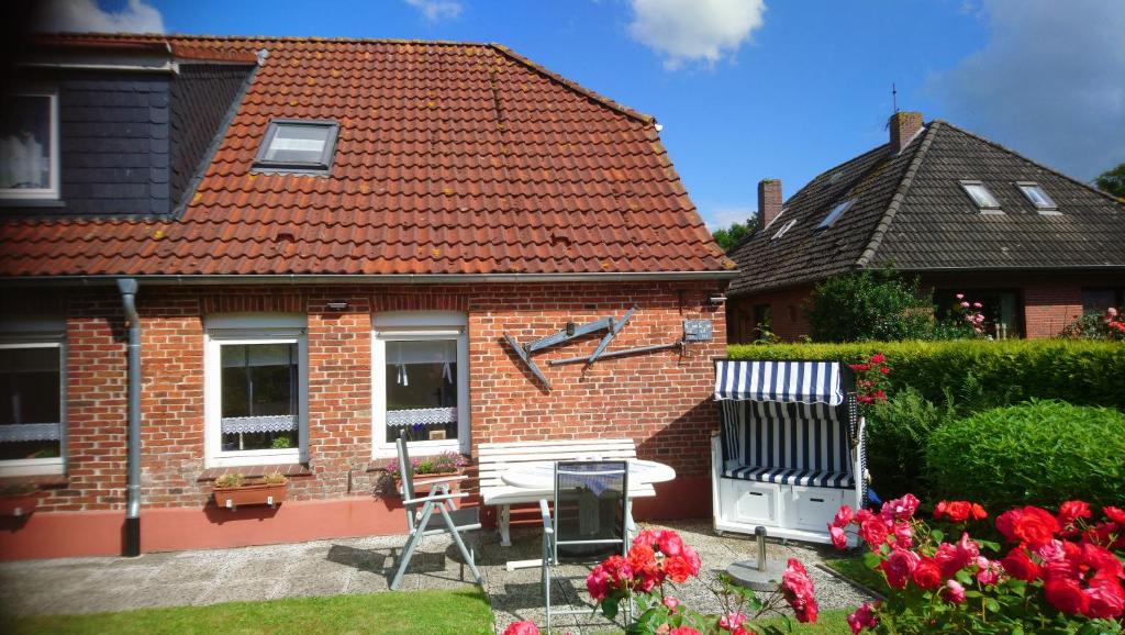 a brick house with a table and chairs in a yard at Ferienwohnung Alte Schmiede in Wangerland