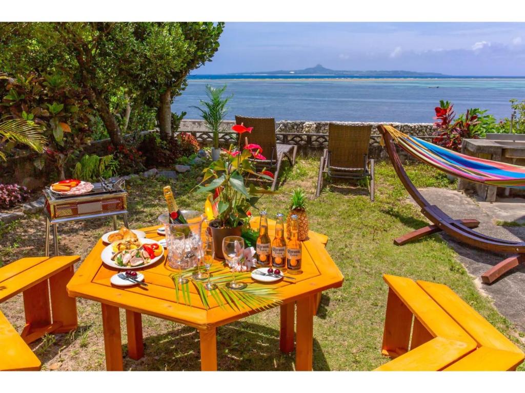 a yellow table with food and drinks on it next to the ocean at Ojii no Ie - Vacation STAY 84243 in Bise