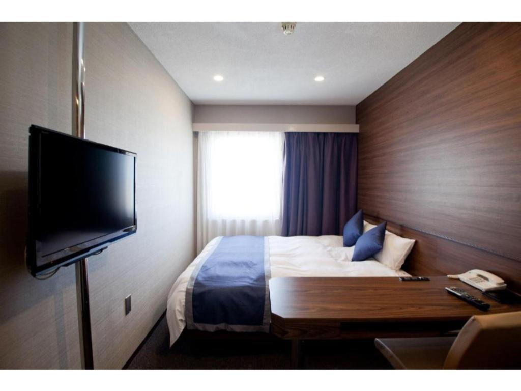 a hotel room with a bed and a flat screen tv at Hotel Il Credo Gifu - Vacation STAY 84599 in Gifu
