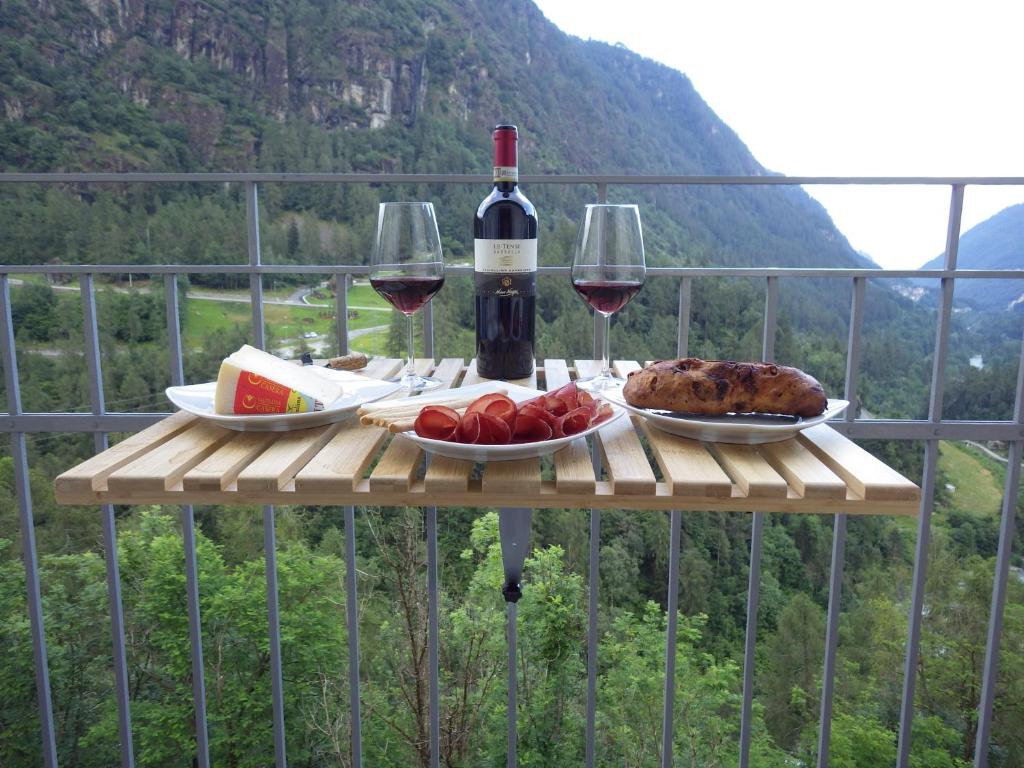 a table with glasses of wine and food on it at AltaValle Holiday Home, monolocale Pink e bilocale Lime in Chiesa in Valmalenco