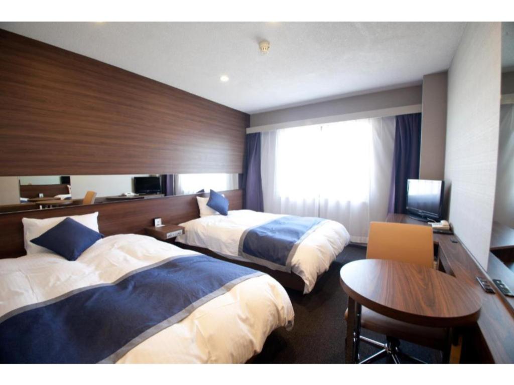 岐阜市にあるHotel Il Credo Gifu - Vacation STAY 84628のベッド2台とテーブルがあるホテルの部屋