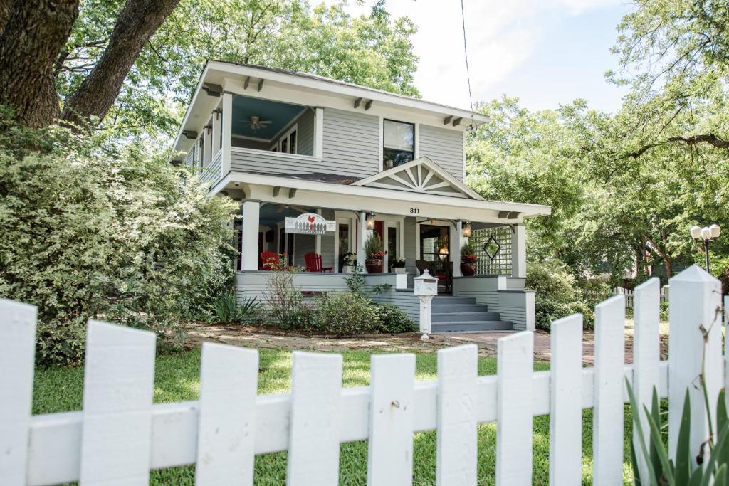 una cerca blanca frente a una casa en Red Gate Inn, en McKinney