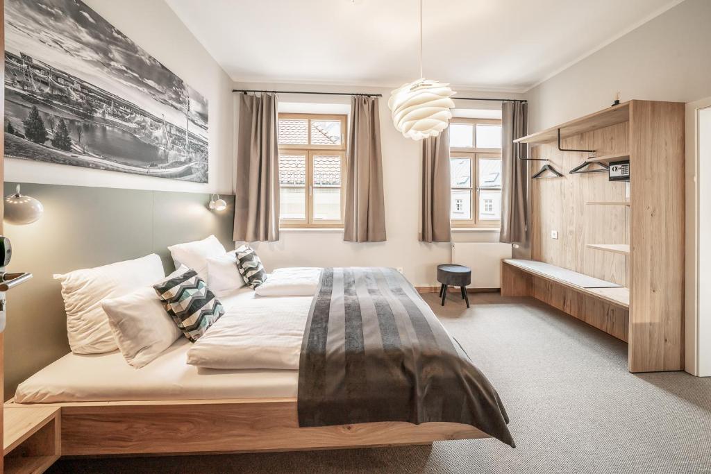 a bedroom with a large bed and a large window at Hotel Am Markt in Munich