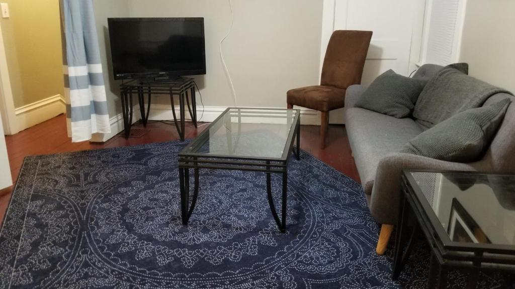 a living room with a couch and a glass coffee table at E Michigan Walk Up Furnished 1 Bedroom APT in Lansing