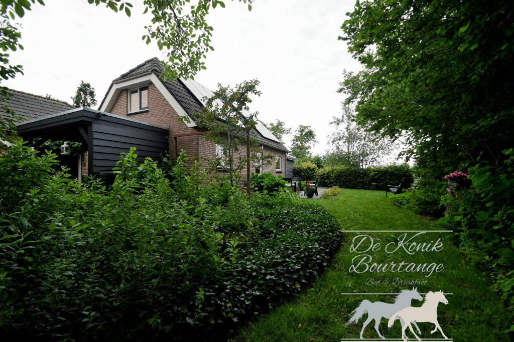 バウルタンゲにあるB&B De Konik Bourtangeの鹿像のある家の庭の看板