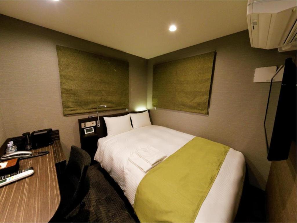 a small bedroom with a bed and a desk with a desk at Act Hotel Roppongi - Vacation STAY 85369 in Tokyo