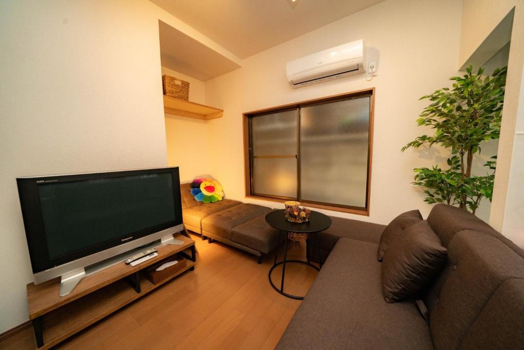 sala de estar con sofá y TV de pantalla plana en Kawanoso - Vacation STAY 8104, en Tokio