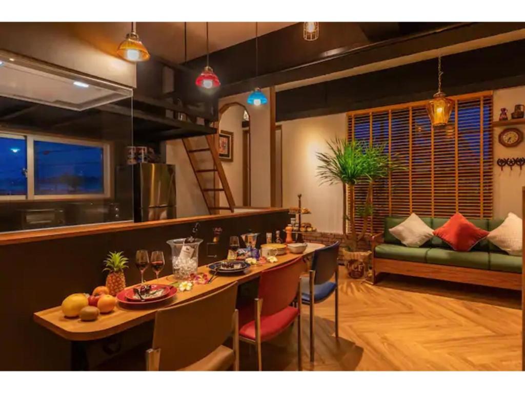 - un salon avec une table et un canapé dans l'établissement GoodDay Hotel - Vacation STAY 84248, à Chatan