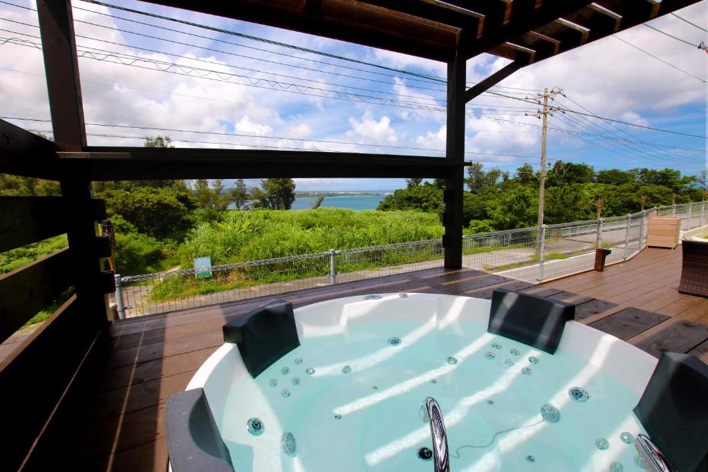 une baignoire sur une terrasse avec vue sur l'océan dans l'établissement Beach Side Secret -SEVEN Hotels and Resorts-, à Ginoza