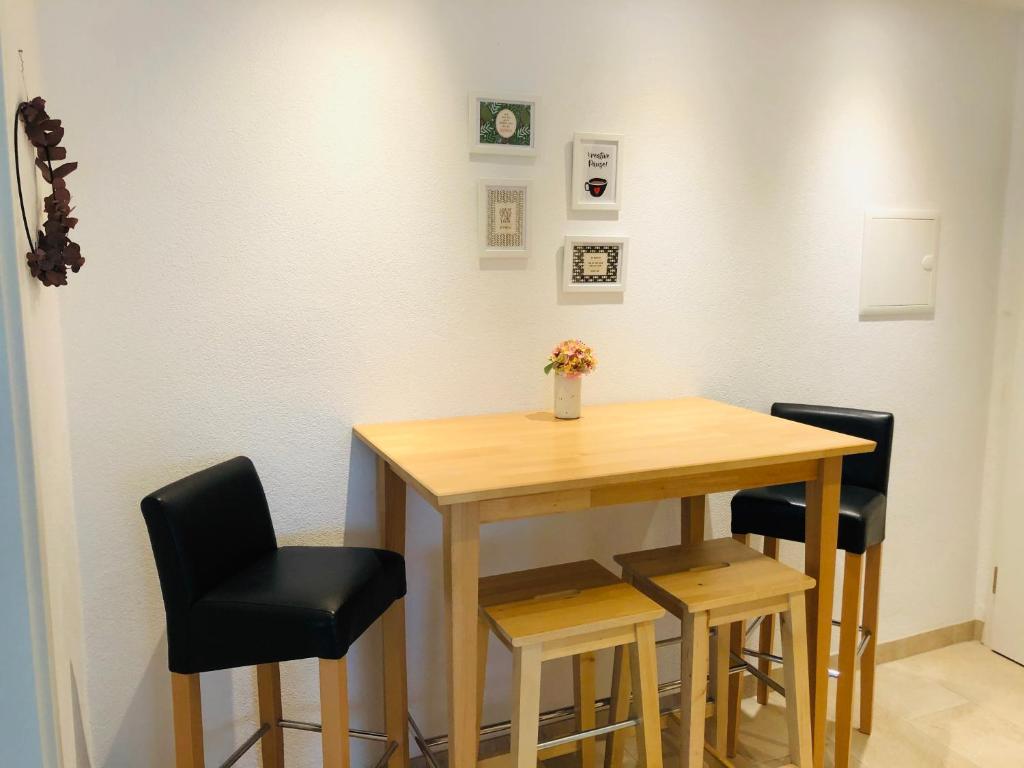 ein Tisch mit vier Stühlen und ein Tisch mit Blumen darauf in der Unterkunft FeWo Im Sonnenbuhl in Konstanz
