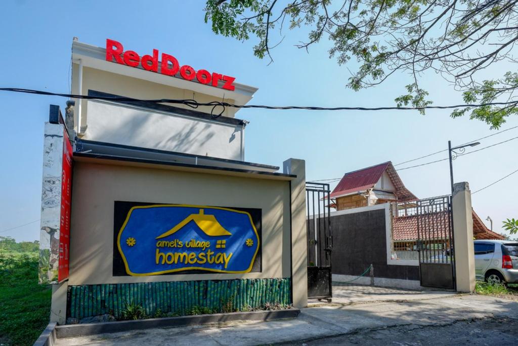 a redbox sign on the side of a building at RedDoorz near Padang Golf Adisucipto in Potrojayan