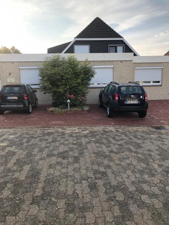 dos autos estacionados frente a una casa en HausTanneneck, en Duhnen
