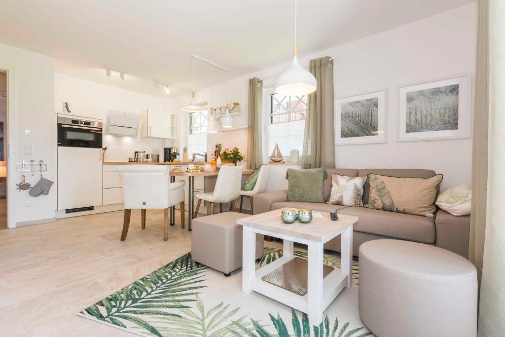 a living room and kitchen with a couch and a table at Sonnenaufgang in Zingst