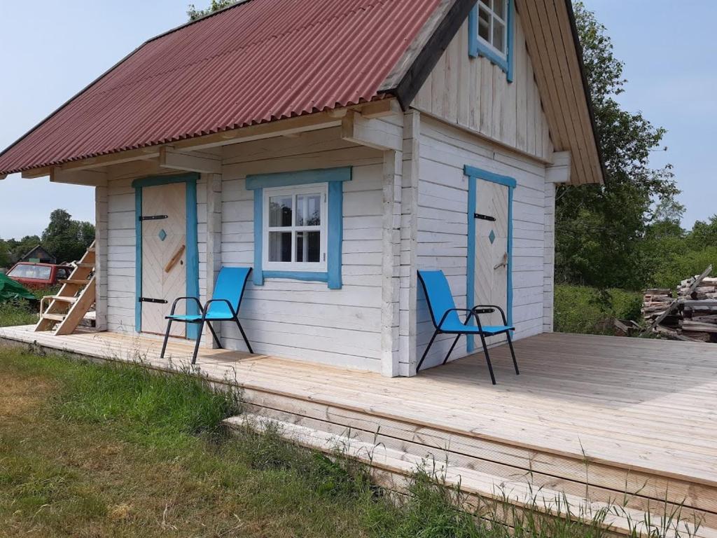 a small cabin with two chairs on a wooden deck at Prangli island Praaga Farmstay in Lääneotsa