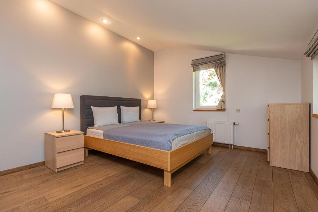 um quarto com uma cama e piso em madeira em S11 em Palanga