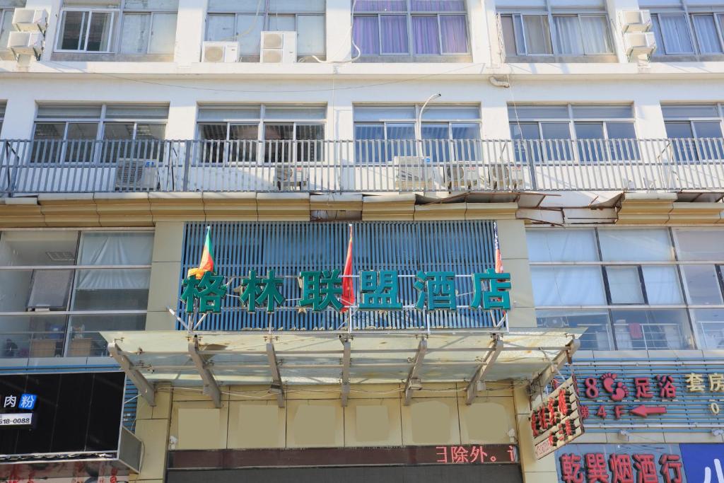 un bâtiment avec un balcon au-dessus dans l'établissement GreenTree Alliance JiangSu SuZhou Industrial Park LianFeng Plaza Hotel, à Suzhou