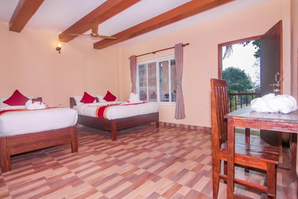 um quarto com duas camas e uma janela em Chitwan Tiger Camp em Sauraha