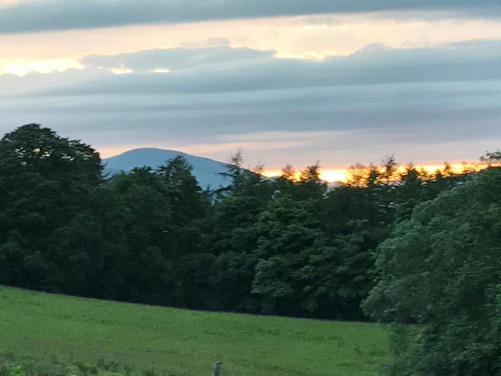 Blick auf einen Berg von einem Feld bei Sonnenuntergang in der Unterkunft Sheildaig Farm in Balloch