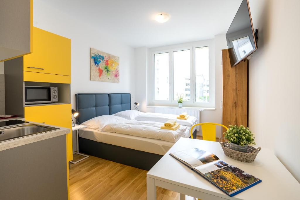 Dormitorio pequeño con cama y mesa en FeelGood Apartments SmartLiving | contactless check-in en Viena