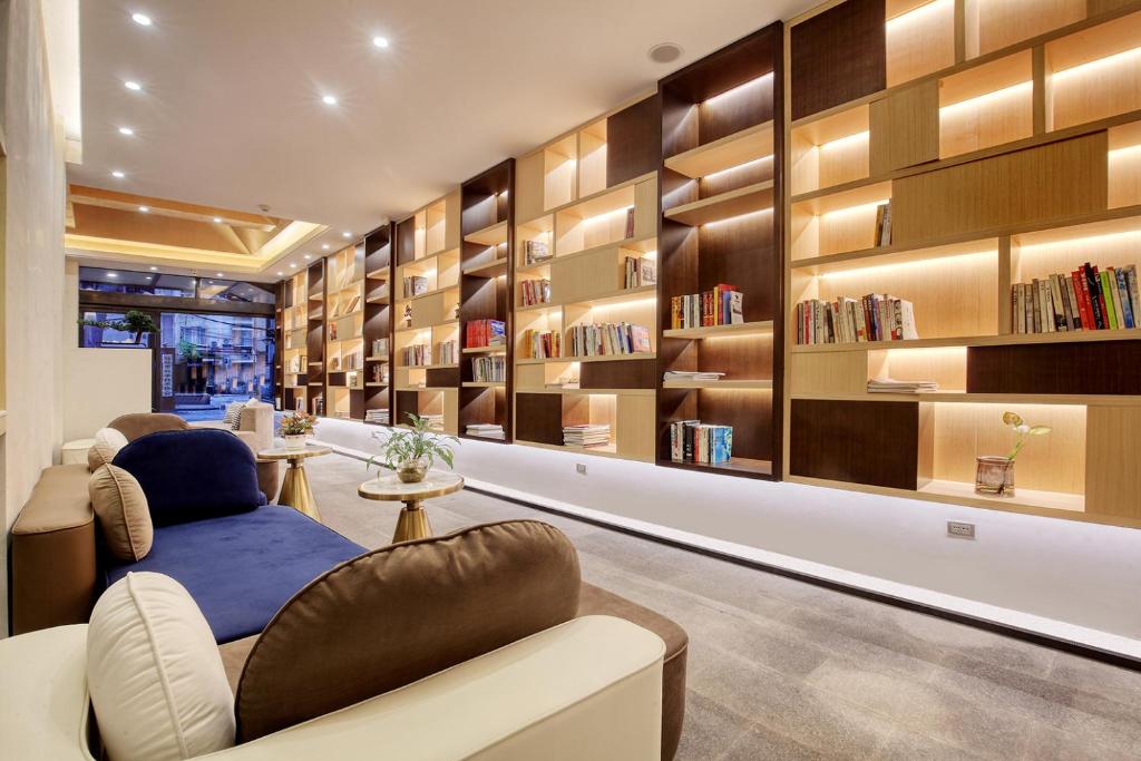 a library with bookshelves and chairs in a room at Wing Hotel Guilin- Pedestrian Street in Guilin